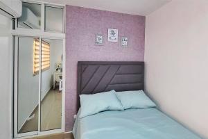 圣地亚哥洛斯卡巴Apartamento acogedor Ashmi的一间卧室配有一张床和紫色的墙壁