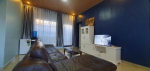 基加利Cozy Nest Oasis - Serviced Apartment的带沙发和平面电视的客厅