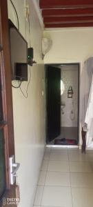 拉穆New Mahrus Hotel Lamu的带淋浴的浴室和墙上的电视