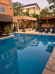 伊瓜苏港法米利亚公寓式酒店的一座大楼前带椅子的游泳池