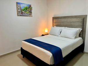 卡塔赫纳Hostal Boutique Casa Pere的一间卧室配有一张带蓝色毯子的大床