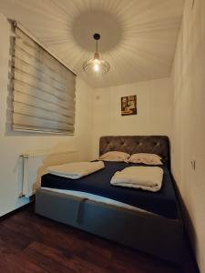 特拉夫尼克Apartments Planinski raj的一间带一张床铺的卧室,位于带天花板的房间内