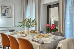 巴黎Romantique 150m2 4CH proche de L'Opéra - Clim的用餐室配有带食物和鲜花的桌子