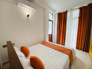 康提Aurelia inn的一间卧室配有床和橙色窗帘的窗户