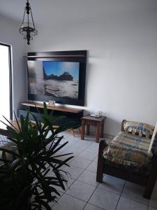 蒙加瓜WI-FI 600MEGA 8 pessoas CENTRO da cidade frente mar 3quartos 2 carros的客厅设有壁挂式平面电视。