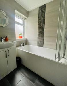 格拉斯哥Clyde 52的白色的浴室设有浴缸和水槽。