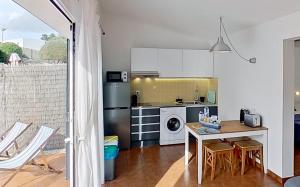 比尼贝卡Apartamento Binibeca Nou Cami de Cavalls的厨房配有桌子和炉灶。 顶部烤箱