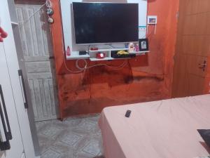 马瑙斯Casa Mobiliada的客厅的墙上配有电视