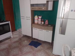 马瑙斯Casa Mobiliada的厨房配有白色冰箱,铺有瓷砖地板。