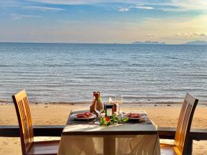 俊穆岛Koh Jum Ocean Beach Resort的海滩上的餐桌,包括食物和饮料