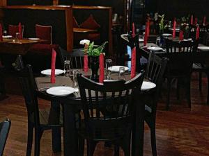 努沃勒埃利耶昆士伍德小屋酒店的一张桌子上摆放着黑椅子和红色蜡烛