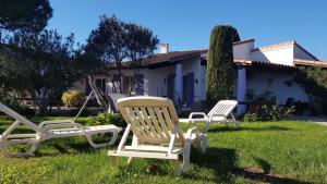 圣马迪拉莫Les Cyprés的两把椅子坐在房子前面的草上