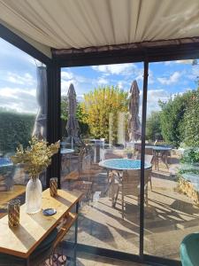 PoissonHôtel La Reconce的一个带桌椅的庭院,并享有花园美景
