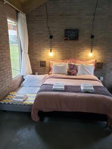 兰舒凯马杜O Chalé Encantado - Rancho Queimado的砖墙客房内的一张大床