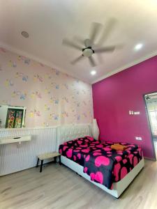 Wakaf BaharuHomestay Wakaf Bharu Tumpat的一间卧室配有一张床和粉红色的墙壁