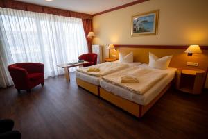 宾茨Hotel Esplanade & Aparthotel Rialto的酒店客房设有一张大床和一张红色椅子。