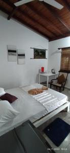 乌纳瓦图纳Full Moon Resort的一张大白色的床,位于带书桌的房间里