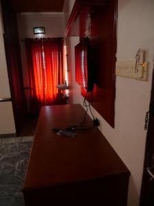 瓦尔卡拉Hosteller's的一间设有桌子和红色窗帘的房间