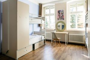 柏林EastSeven Berlin Hostel的一间卧室配有双层床和书桌