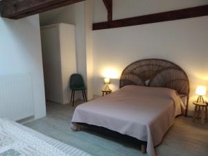 莱瑟佩瑟Les Trois Geais的一间卧室配有一张大床和两盏灯。