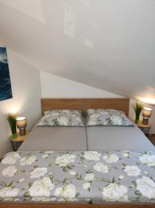 比尔森Wellness apartmán s vířivkou a saunou的一张床上的床单,上面有白色的花朵