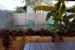 奥拉迪亚Cozy Cottage - Free Parking, Self Check-in的花园设有桌椅和围栏