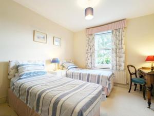 埃姆斯沃思Thorney Road的一间卧室设有两张床、一张桌子和一个窗口。