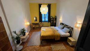 佩奇NAPartman Pécs的一间卧室配有一张黄色床罩的床