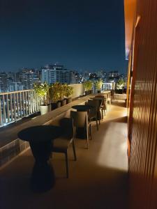 圣保罗Flat / Studio Allianz Parque的夜晚阳台上的一排桌椅