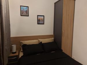 圣保罗Flat / Studio Allianz Parque的卧室配有一张黑色床,墙上挂有两张照片