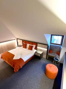 锡比乌Loft by Lumiere Sibiu的一间卧室配有一张带橙色床罩的大床