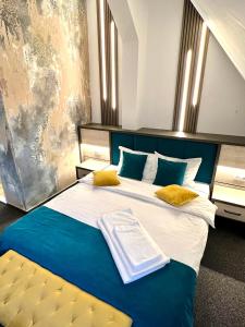 锡比乌Loft by Lumiere Sibiu的卧室配有蓝色和白色的床以及黄色枕头