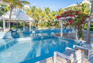 Turtle CoveThe Yacht Club Penthouse C14的棕榈树和鲜花度假村的游泳池