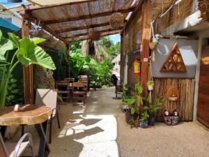 巴卡拉尔Hakuna Matata Glamping的户外餐厅,配有桌椅和植物