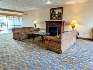 莱克哈莫尼The Willowbrook Golf Hotel At Split Rock的客厅设有两张沙发和一个壁炉