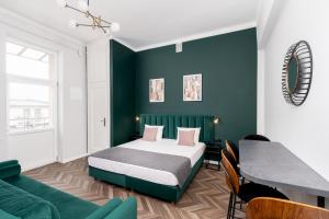 克拉科夫Wawel Boutique Residence - Krakow Old Town的一间卧室设有一张床和绿色的墙壁