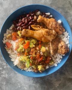 洛维托斯Tayta Surf House的蓝色的碗,有米饭,鸡和豆子