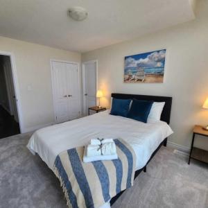 索罗尔德New Niagara Retreat - Entire Home, 15 min drive to Falls, Sleeps 9, 4BDR的卧室配有带蓝色枕头的大型白色床