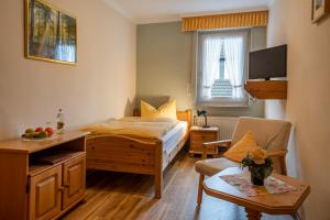 温特贝格波斯特乡村酒店的一间卧室配有一张床、一把椅子和一张桌子