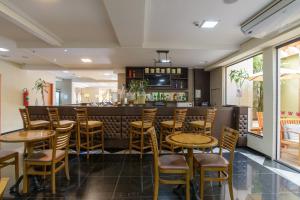 阿蒂巴亚Faro Hotel Atibaia的一间带木凳的餐厅和一间酒吧