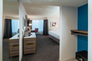诺克罗斯诺克罗斯桃树角花园广场酒店的配有一张床和一张书桌的酒店客房