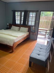 象岛KANNIKA RESORT的一间卧室配有一张床、一把椅子和窗户。