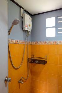 象岛KANNIKA RESORT的浴室铺有橙色瓷砖,设有淋浴。