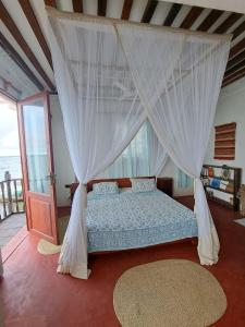 拉穆Pwani House - Lamu Seafront的一间卧室配有一张带天蓬的床