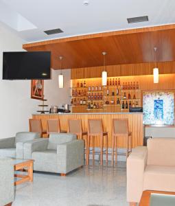 蓬蒂-达巴尔卡Hotel O Guerreiro的大堂设有带椅子和电视的酒吧