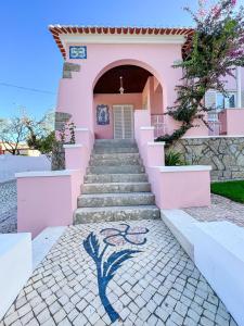 辛特拉Chalet do Eléctrico 92'的粉红色的房子,有楼梯,上面有画