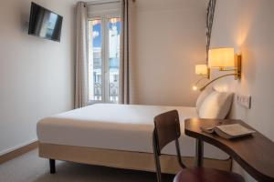 巴黎金太平洋酒店的客房设有床、书桌和窗户。