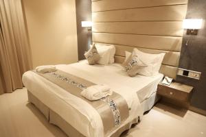 哈伊勒الماسةالتاج للشقق الفندقية的酒店客房配有带白色床单和枕头的床。