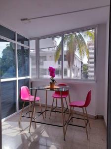 巴拿马城R-8 Amplio apartamento en zona turística.的用餐室配有粉红色的椅子和桌子