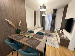 亚霍里纳FORESTA Apartment Jahorina的客厅配有木桌和蓝色椅子